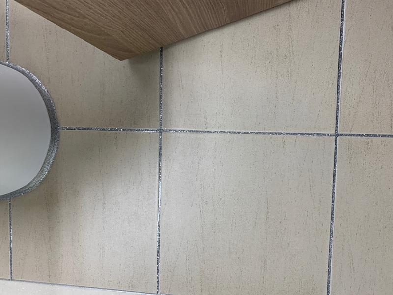 벽면 타일 패턴 사이의 은색 마감재
