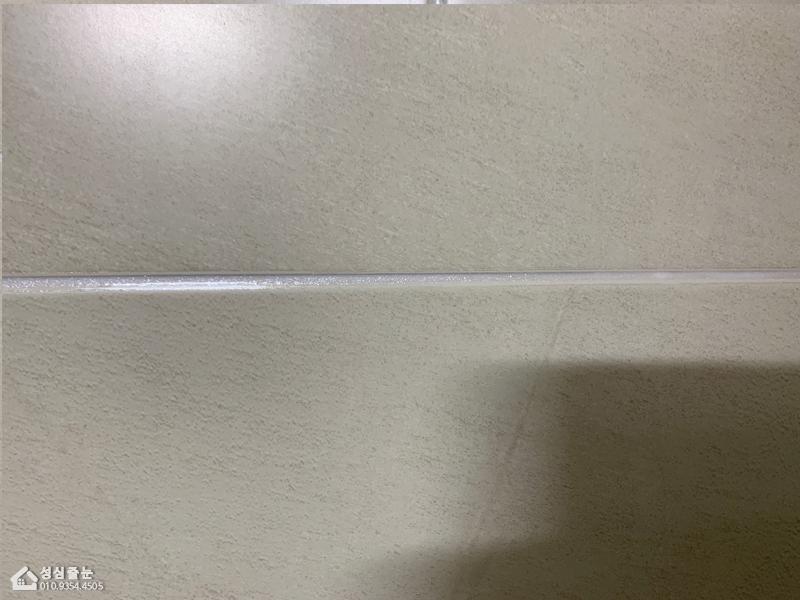 벽면 텍스처 마감과 중앙의 흰색 실리콘 선