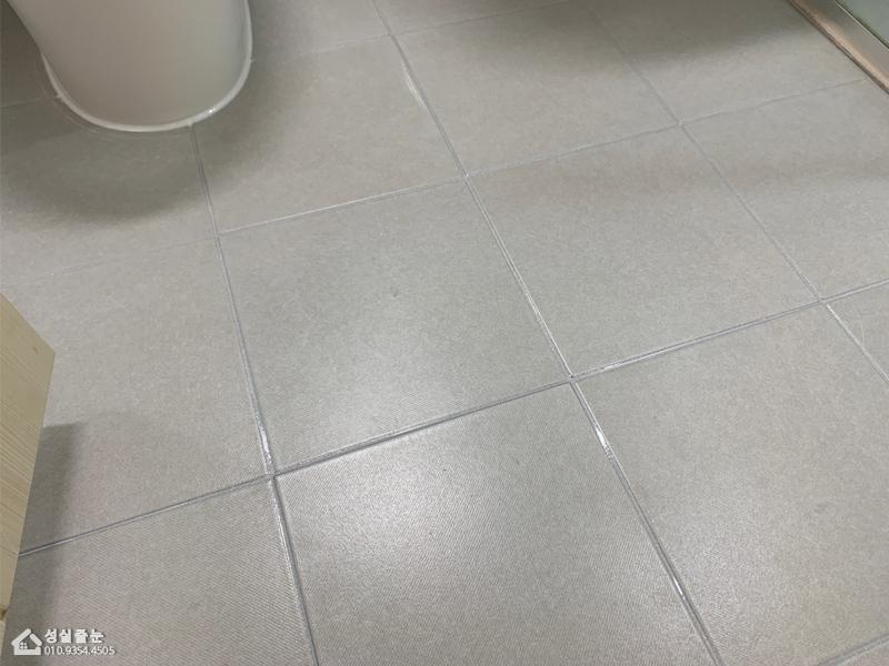 회색 타일 바닥과 세면대 주변의 기초 작업 모습