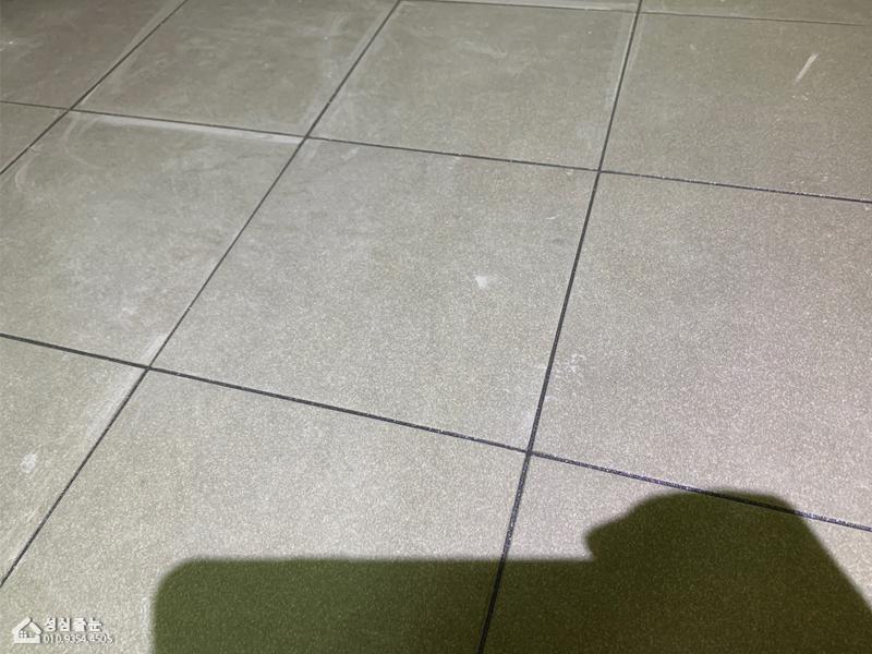 회색 타일 사이의 흰색 실시공 틈