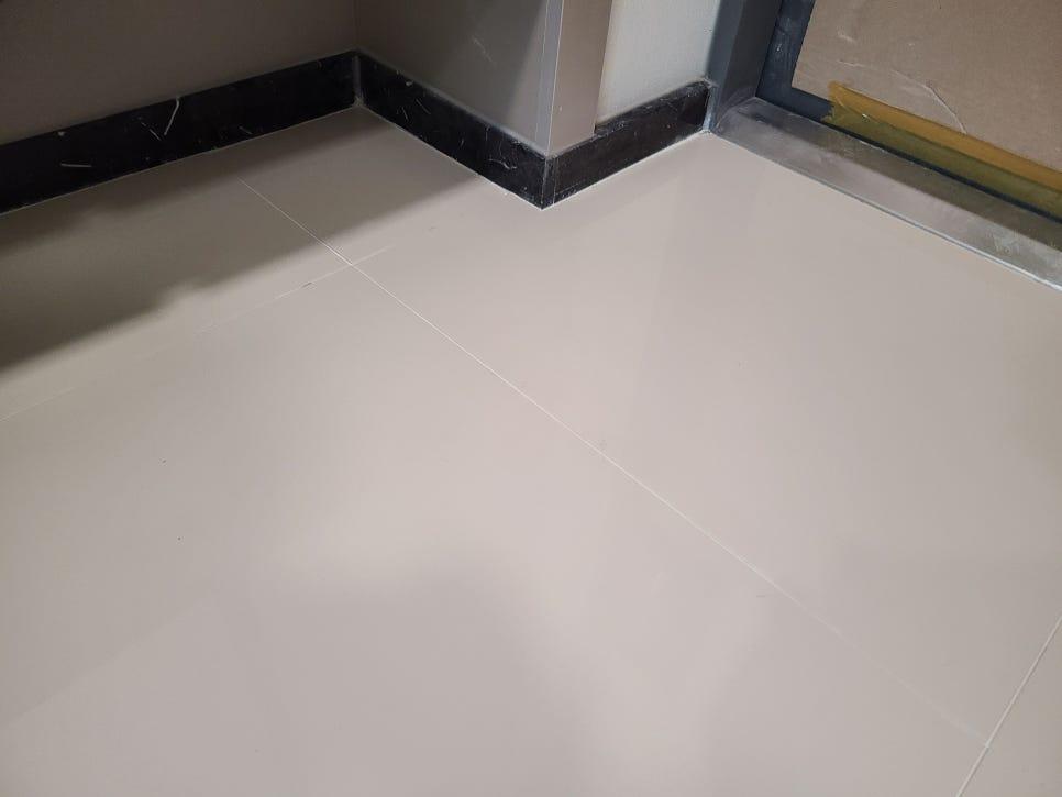 흰색 타일 바닥과 검은색 베이스보드 접합부