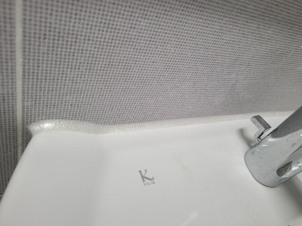 KELIM 로고의 세라믹 싱크볼과 금속 수전이 있는 욕실