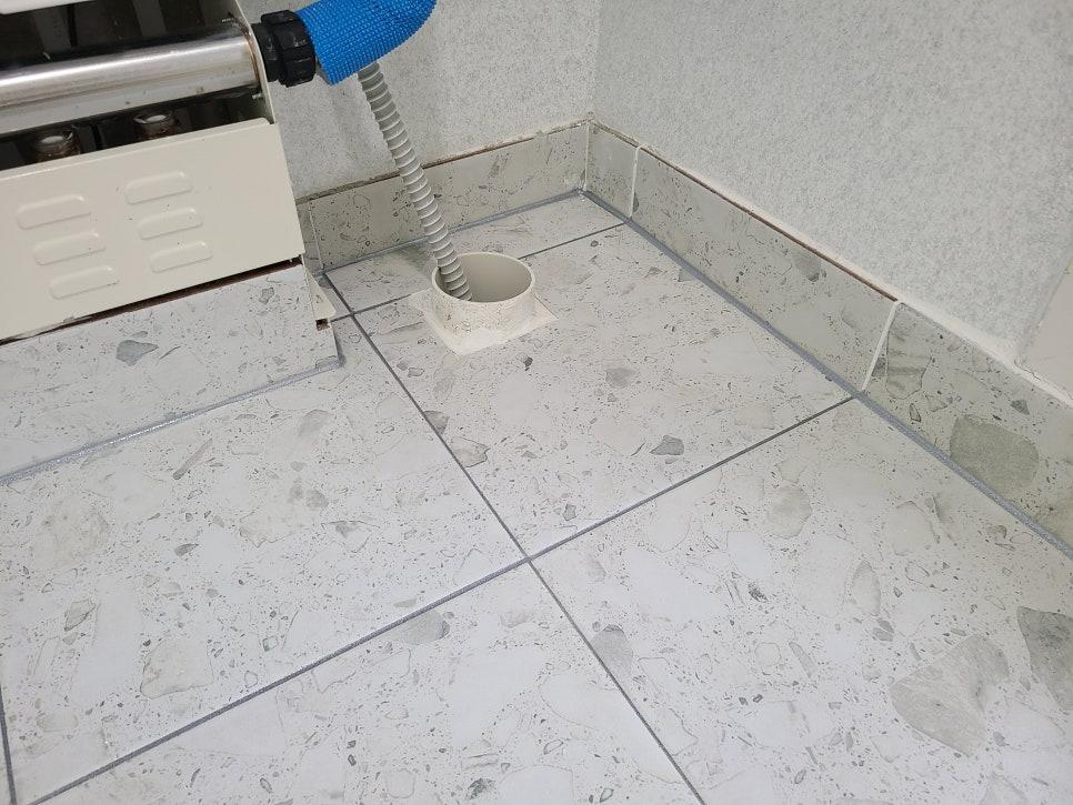 파란색 끝의 펌프가 놓인 흰색 타일 바닥