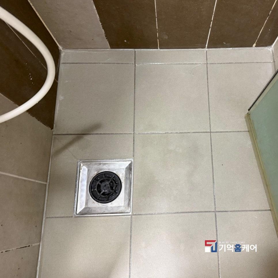 회색 타일과 검은색 배수구가 어우러진 바닥