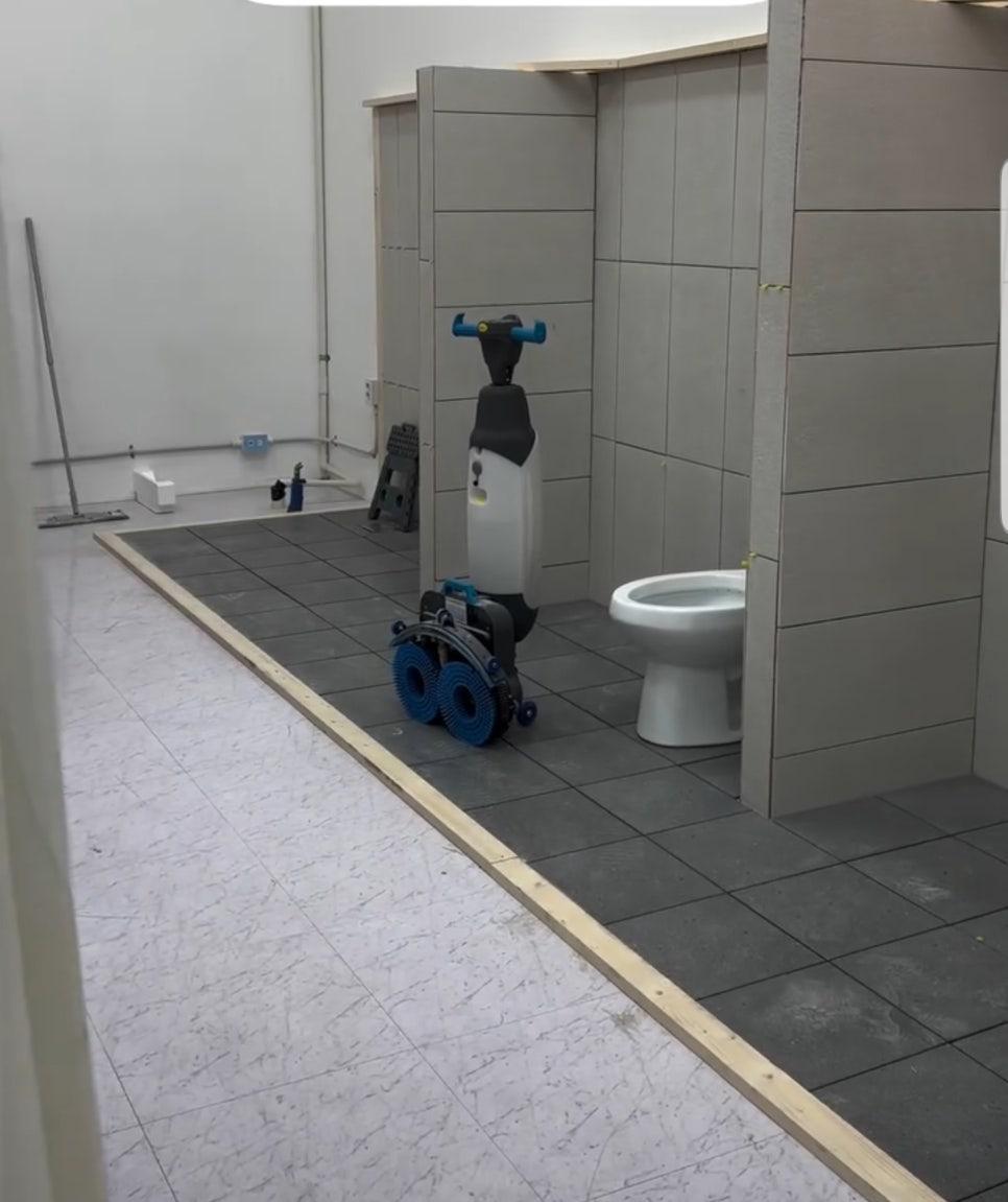 회색 벽과 검은 바닥 타일로 완성된 화장실