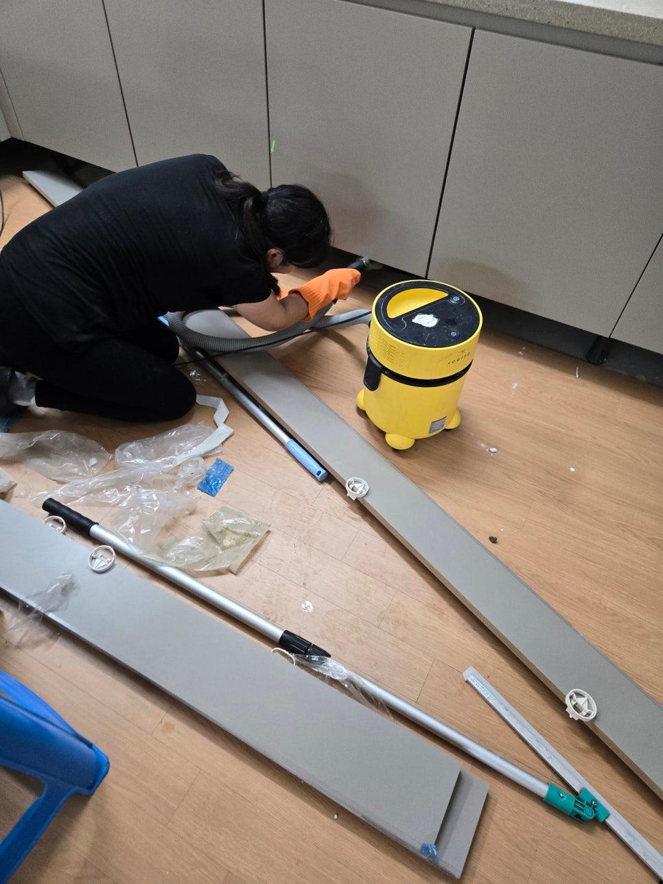 청소 도구들과 함께 정리 중인 바닥 공간