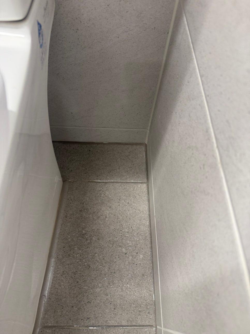 회색 타일로 마감된 욕실 바닥과 벽 시공 과정