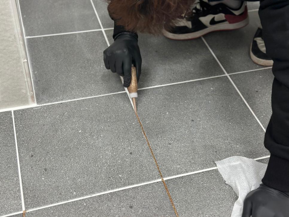 회색 타일 사이에 접착제를 주입하는 과정