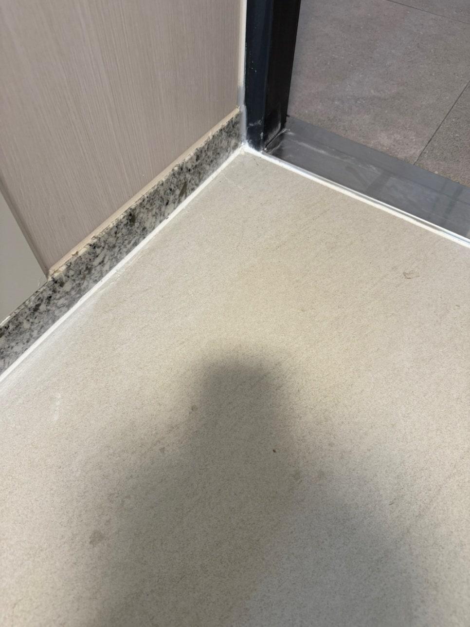문틀과 바닥 틈새에 붙인 마스킹 테이프