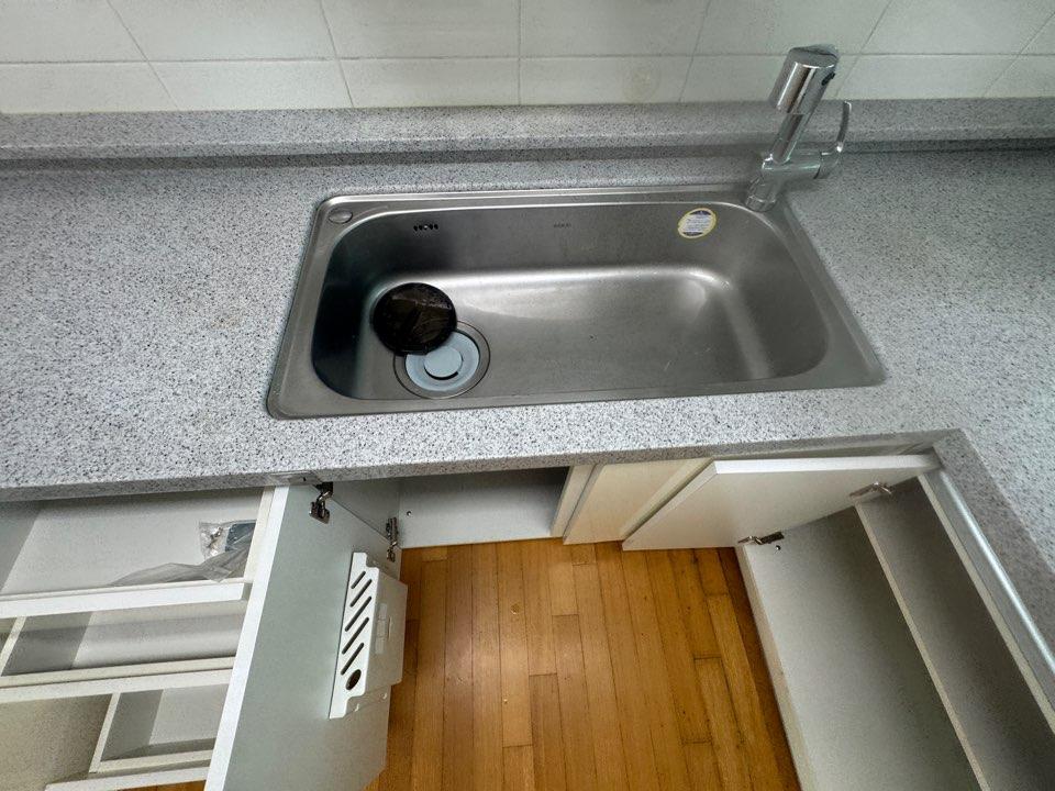 그레이 톤 상판과 밝은 수납장이 있는 주방