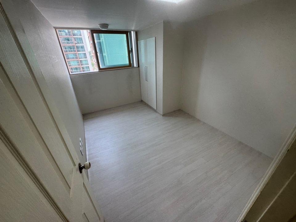흰 벽과 흰색 목재 바닥이 있는 빈 방