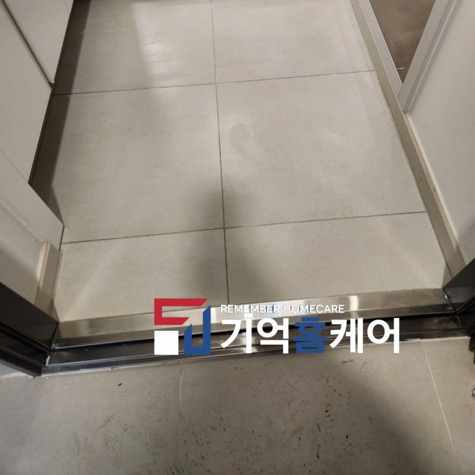 흰색 타일 바닥과 금속 프레임 문이 있는 복도