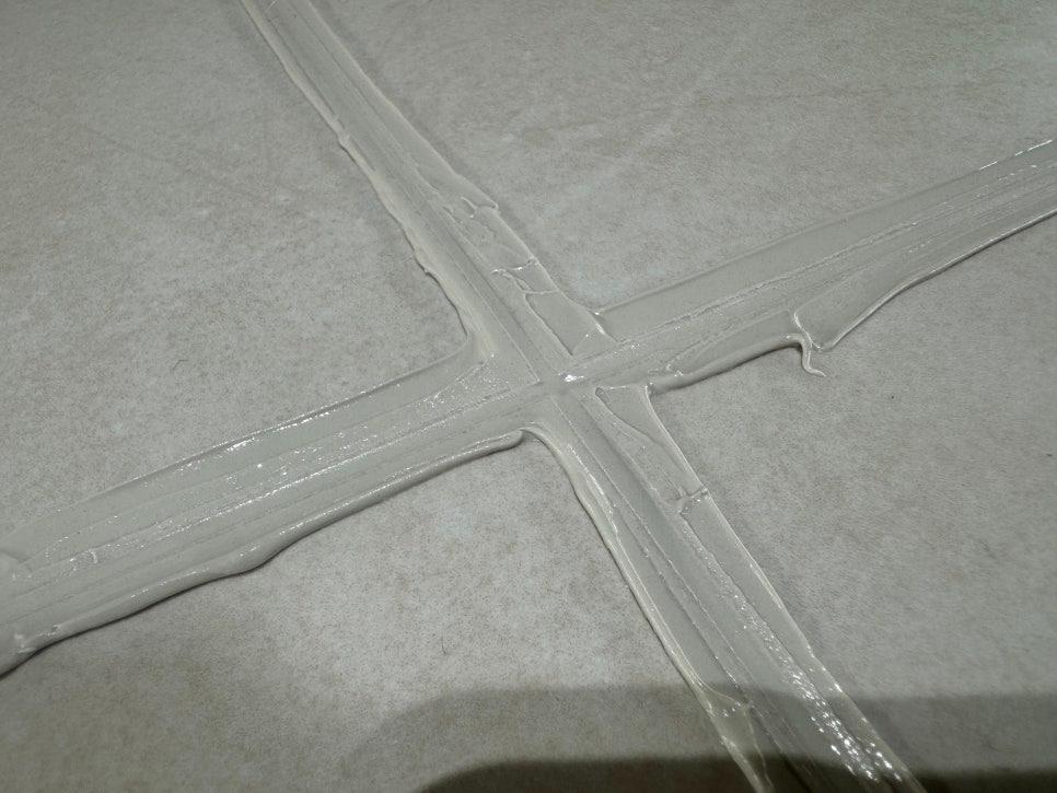 흰색 타일 바닥의 실리콘 경계선 마감