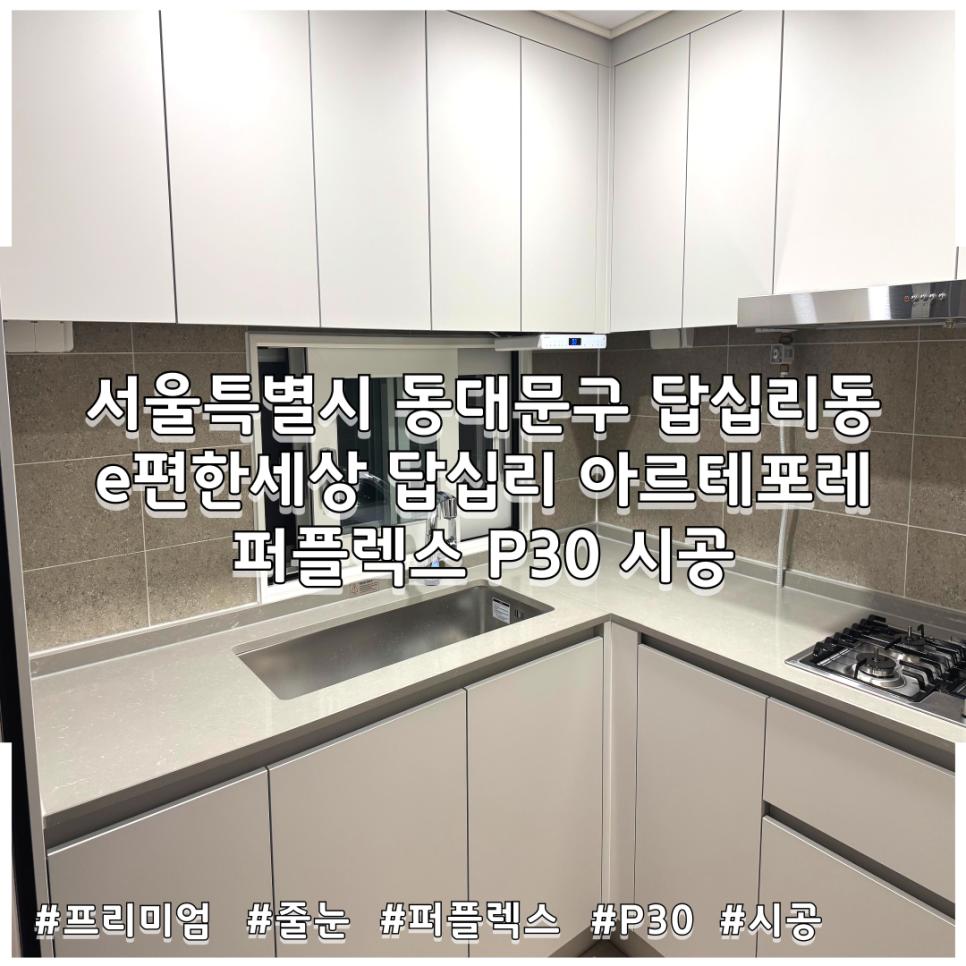 베이지색 타일 벽면과 흰색 상판이 있는 주방