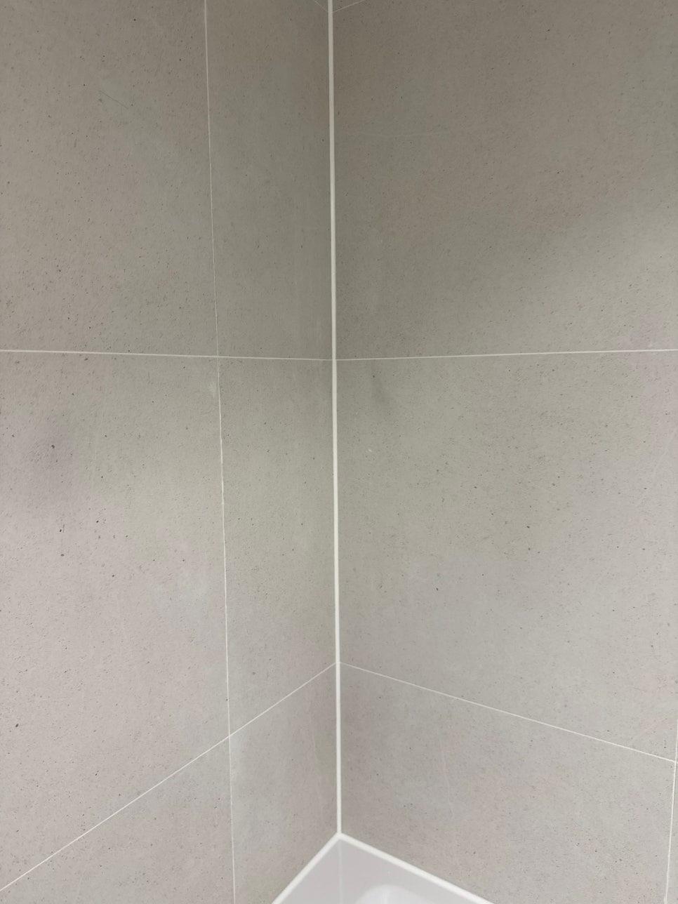 회색 타일 벽면과 흰색 세라믹 타일 코너 작업