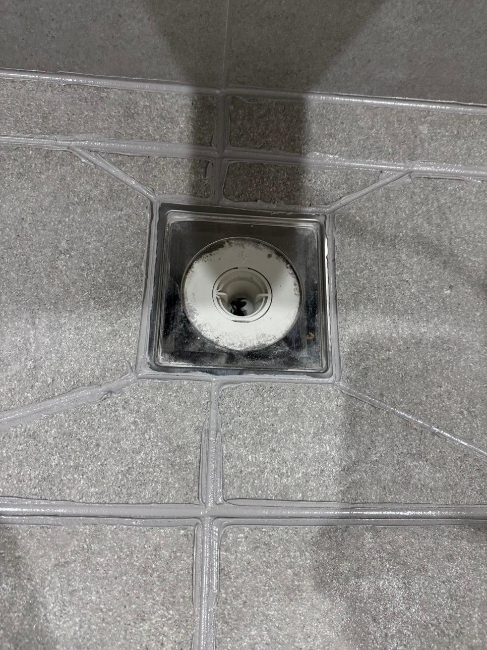바닥 중앙 흰색 수전 주변의 시공 상태