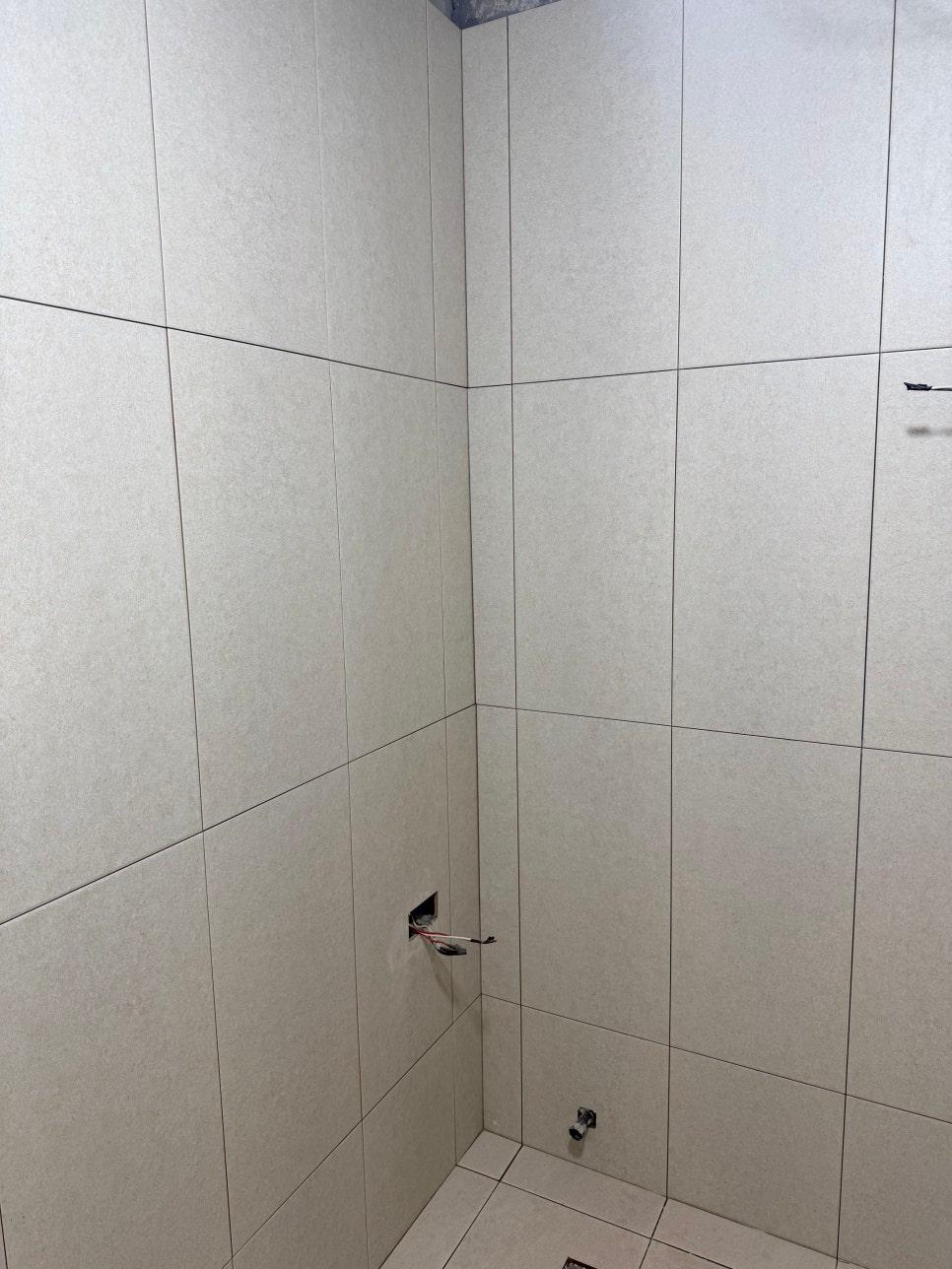 배선이 노출된 흰색 타일 벽면