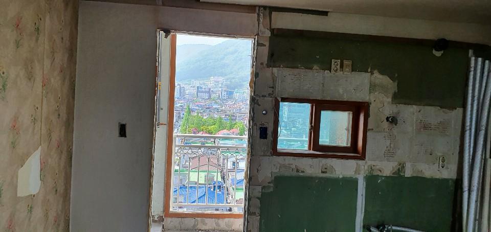 녹색 페인트와 흰색 마감재가 보이는 창호 주변 공사 현장