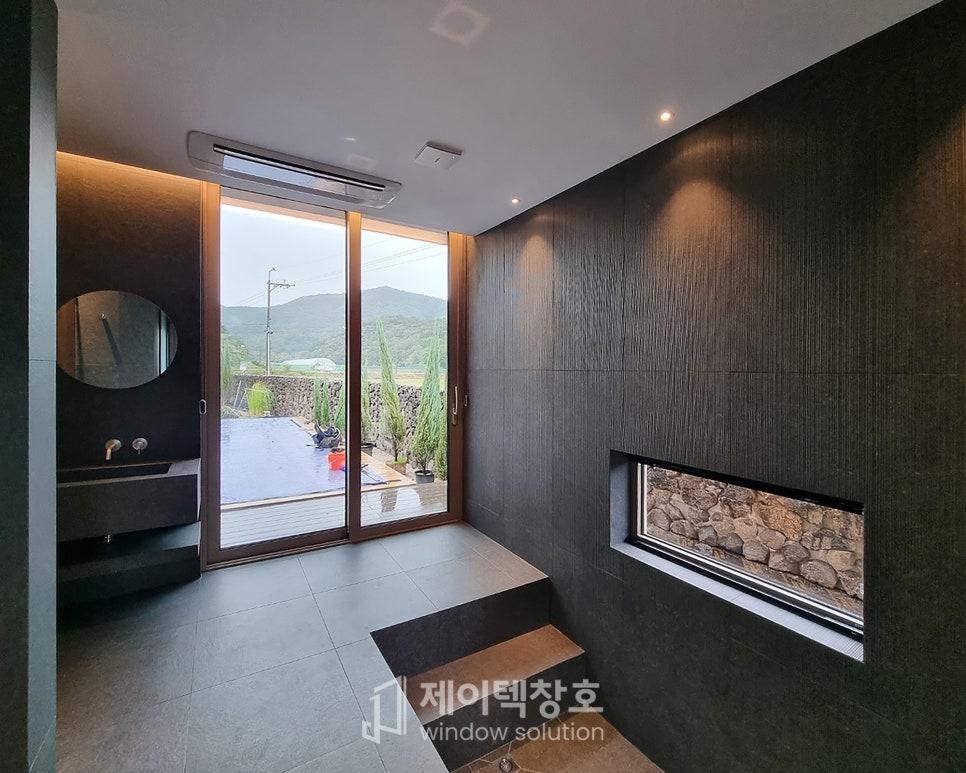 검은색 우드톤 벽면과 유리 슬라이딩 도어가 있는 욕실