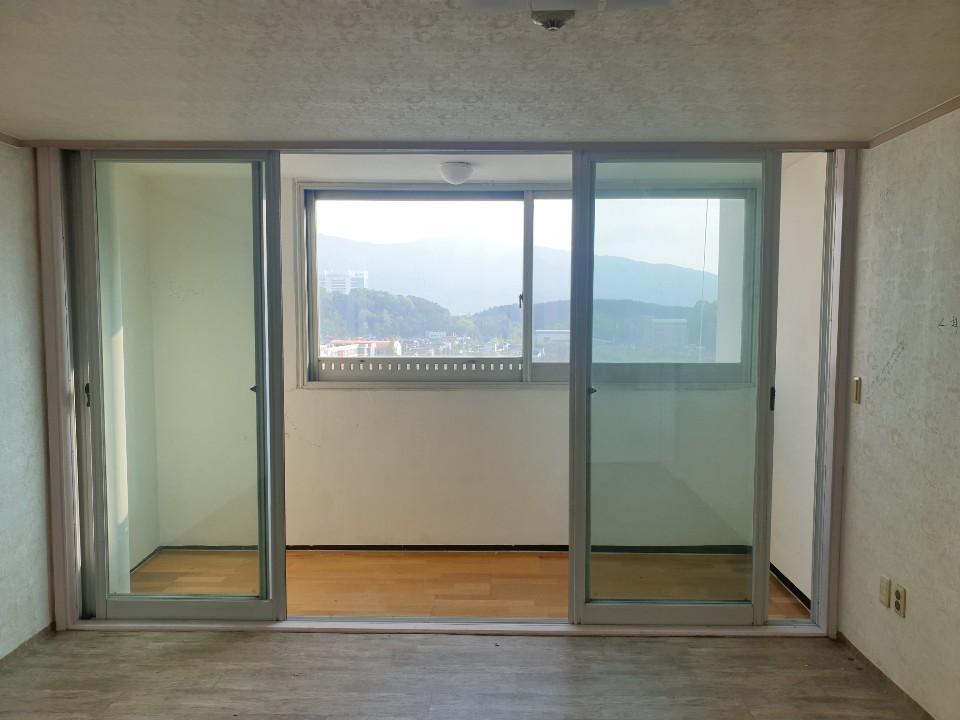 목재 바닥과 슬라이딩 유리문이 설치된 발코니