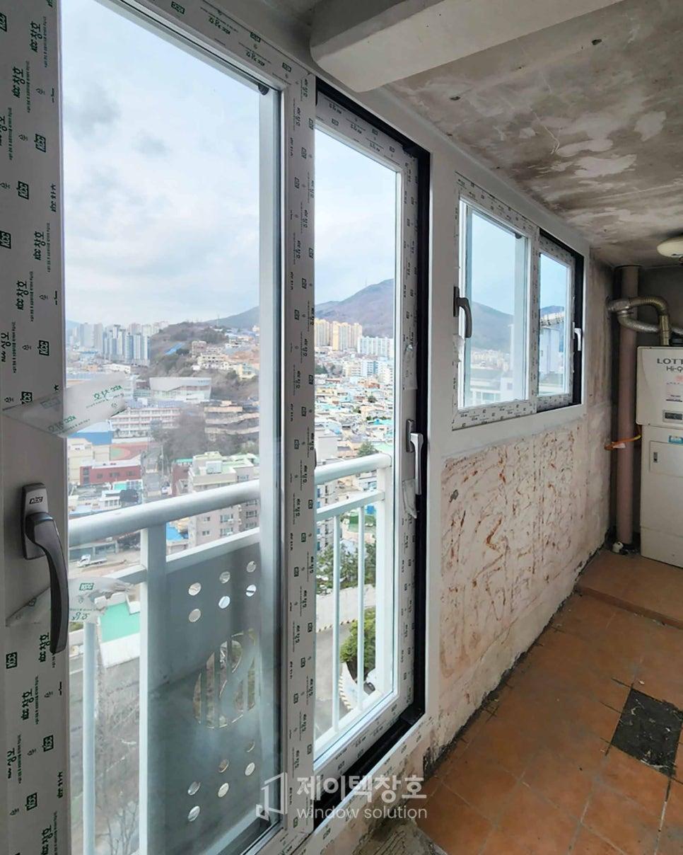 도시 풍경을 배경으로 설치 중인 발코니 창호