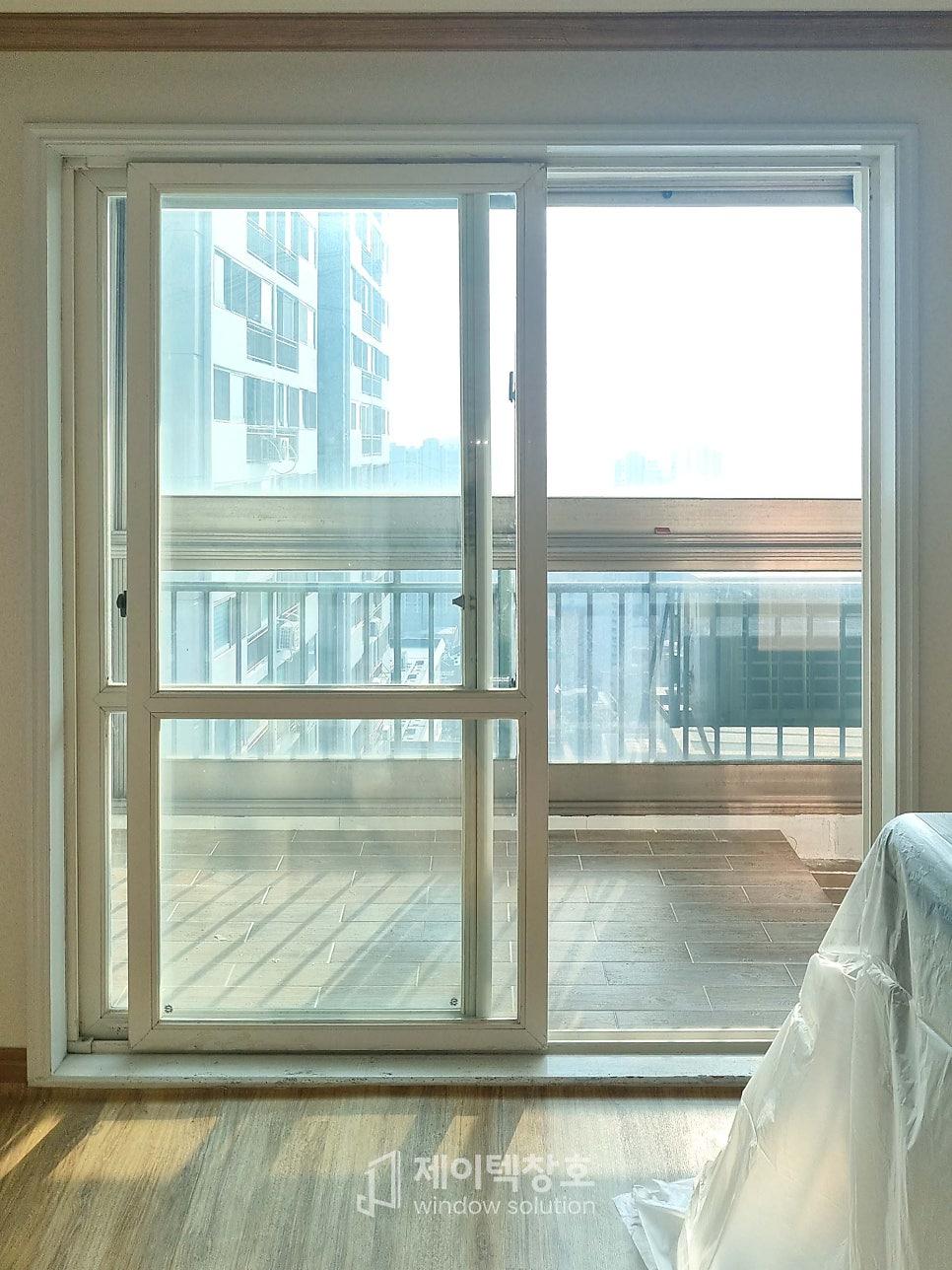 베이지색 벽지와 목재 마루가 있는 거실 내창 시공 모습