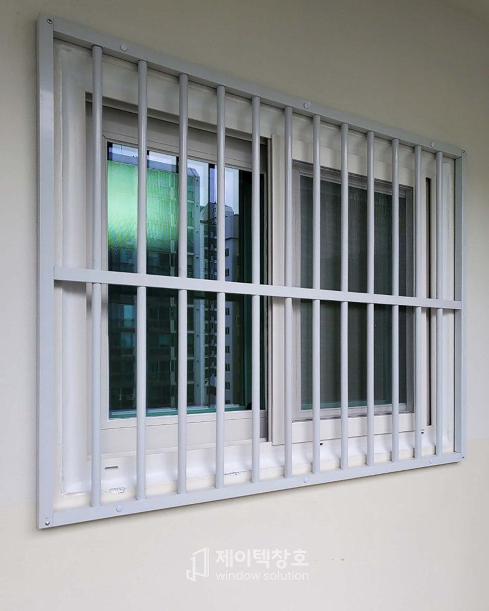 회색 금속 방범창이 설치된 창호 근접 모습