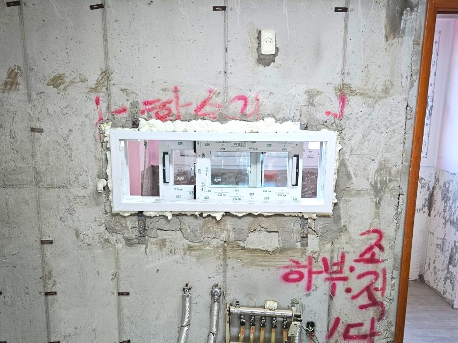 콘크리트 벽면에 붉은 글씨가 적힌 시공 전 상태