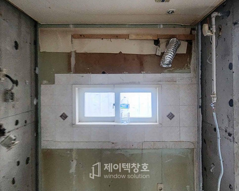 배관이 노출된 벽면에 설치 중인 주방 프로젝트창