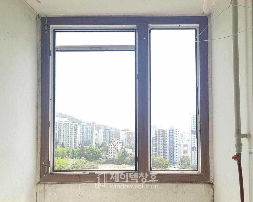 갈색 프레임 창호 너머로 보이는 녹지