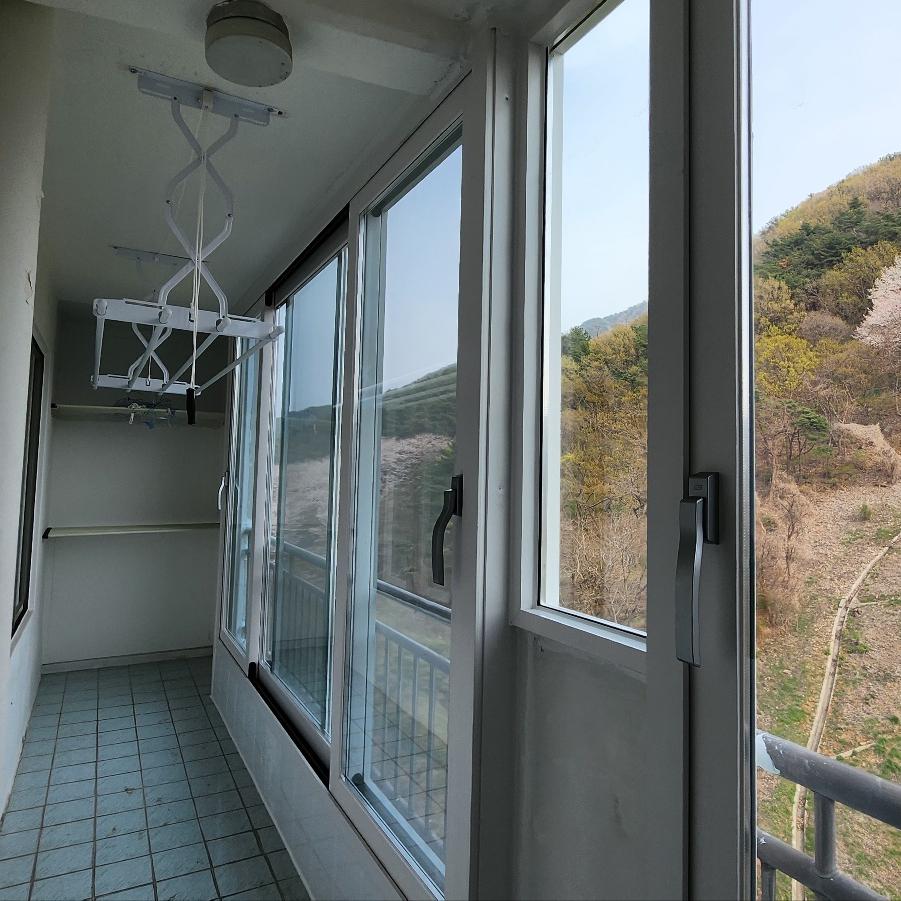 흰색 건조대와 산 풍경이 어우러진 창가