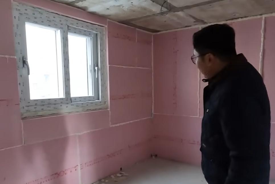 분홍색 벽면과 천장 구조물이 노출된 빈 공간