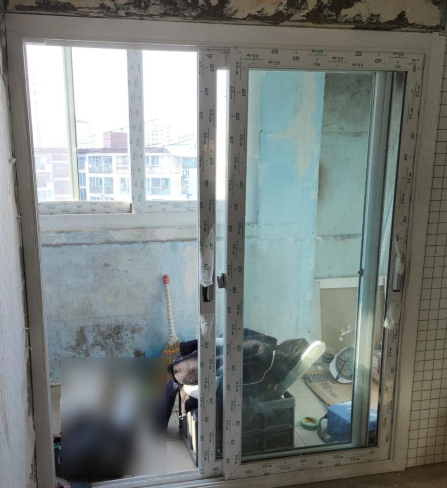 창호 손잡이 부근에서 수공구로 조정 중인 모습