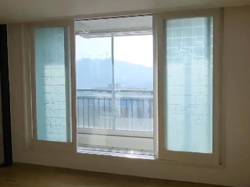 외부 레일과 배경 산이 보이는 창호 근접 샷