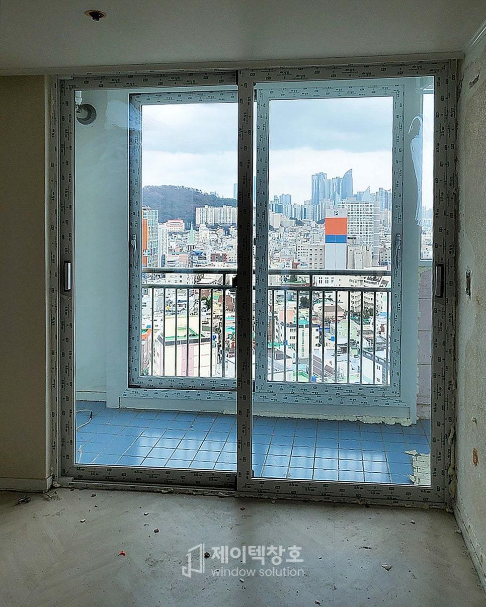 화이트 프레임 너머로 도시 풍경이 보이는 창호