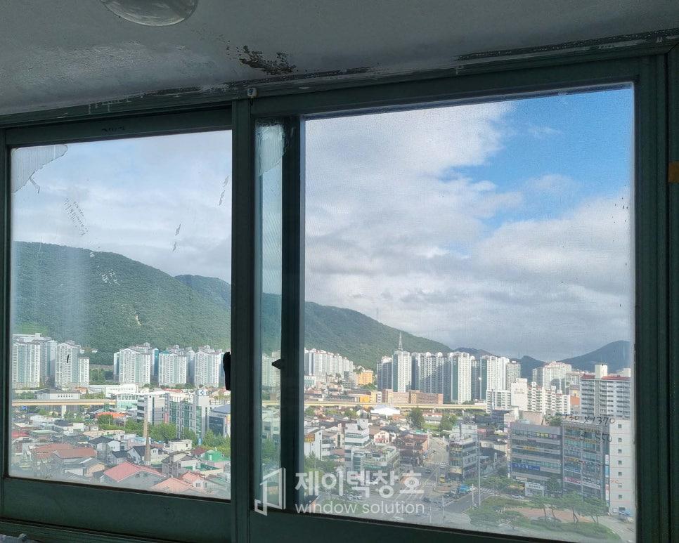 도시 풍경이 비치는 창호 프레임의 근접 모습