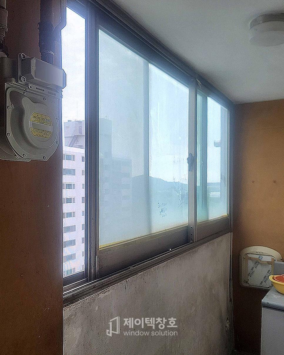 주방 가구와 전기 박스가 보이는 창호 프레임 근접 샷