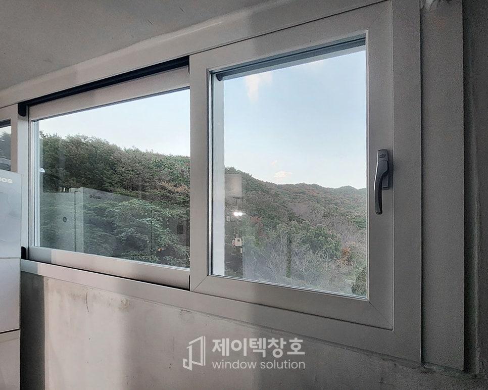 회색 톤 창호 너머로 산과 나무 풍경이 보이는 다용도실