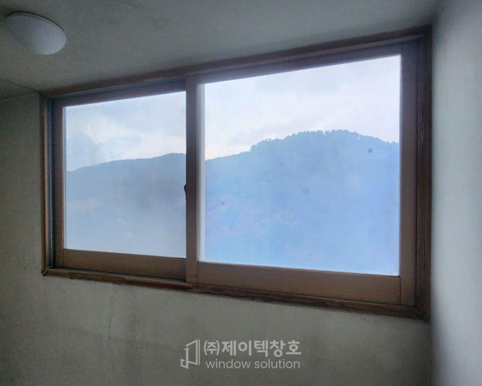 산 풍경이 보이는 나무 프레임 창호 작업 모습