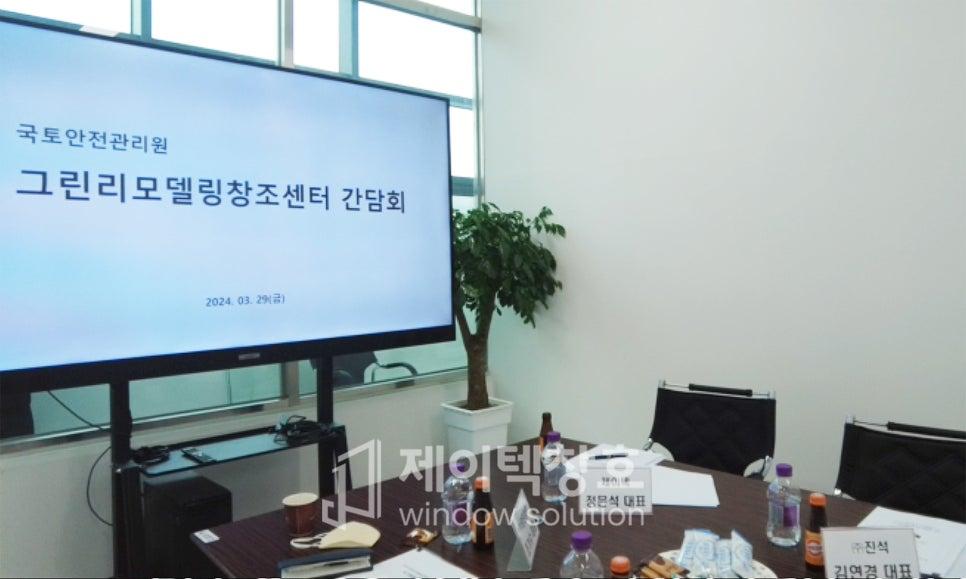 간담회 일정이 표시된 스크린과 회의 자료가 놓인 테이블
