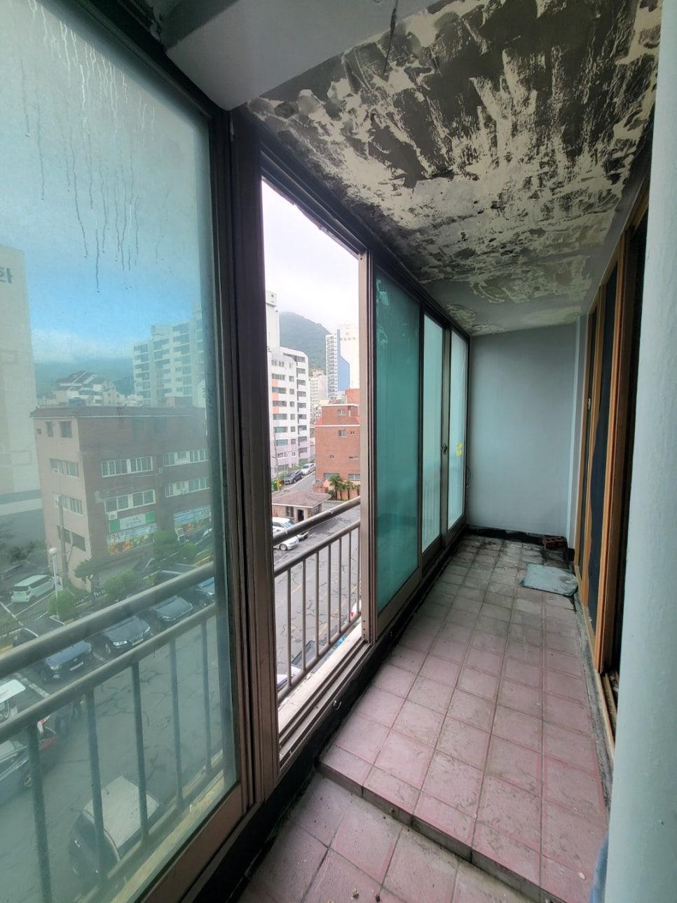 분홍색 타일과 벗겨진 천장이 드러난 발코니 전경