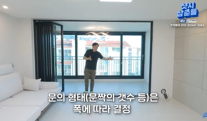 블랙 프레임 슬라이딩 창호가 설치된 거실 내부