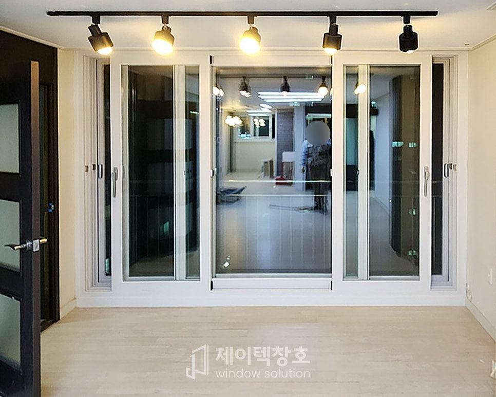 화이트 프레임 슬라이딩 창호가 설치된 밝은 복도