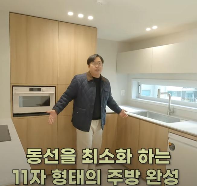우드톤 바닥과 화이트 수납장으로 완성된 주방