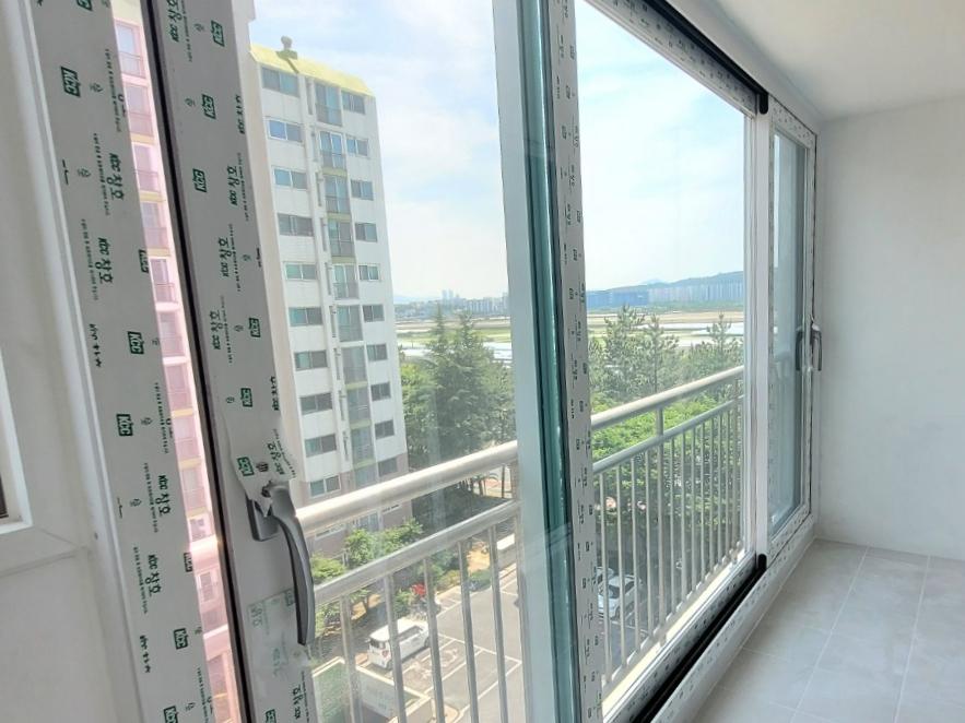 흰색 벽면과 밝은 타일 바닥 위에 설치된 외부 창호