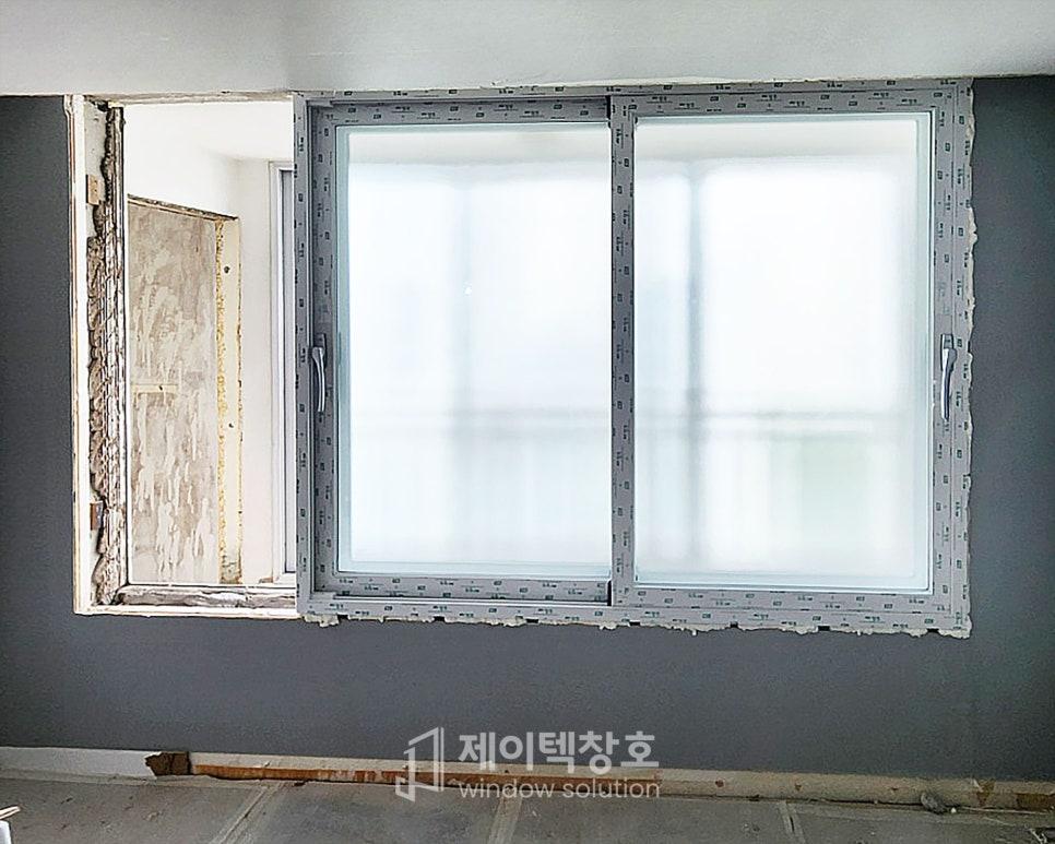 회색 프레임의 창호가 설치 중인 벽면과 철거된 벽체