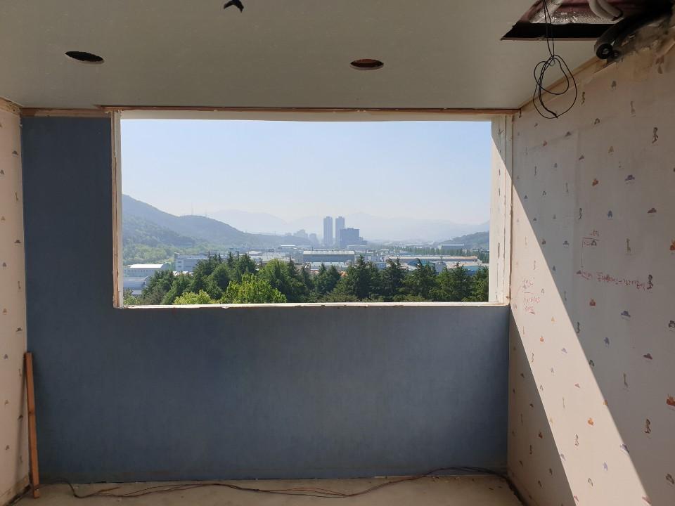 벽지가 붙은 벽과 천장 구멍이 보이는 시공 공간
