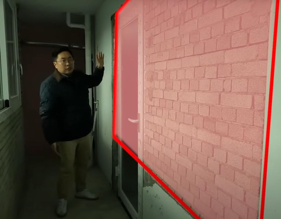 벽돌 벽과 문이 설치된 복도 공간의 작업 상태