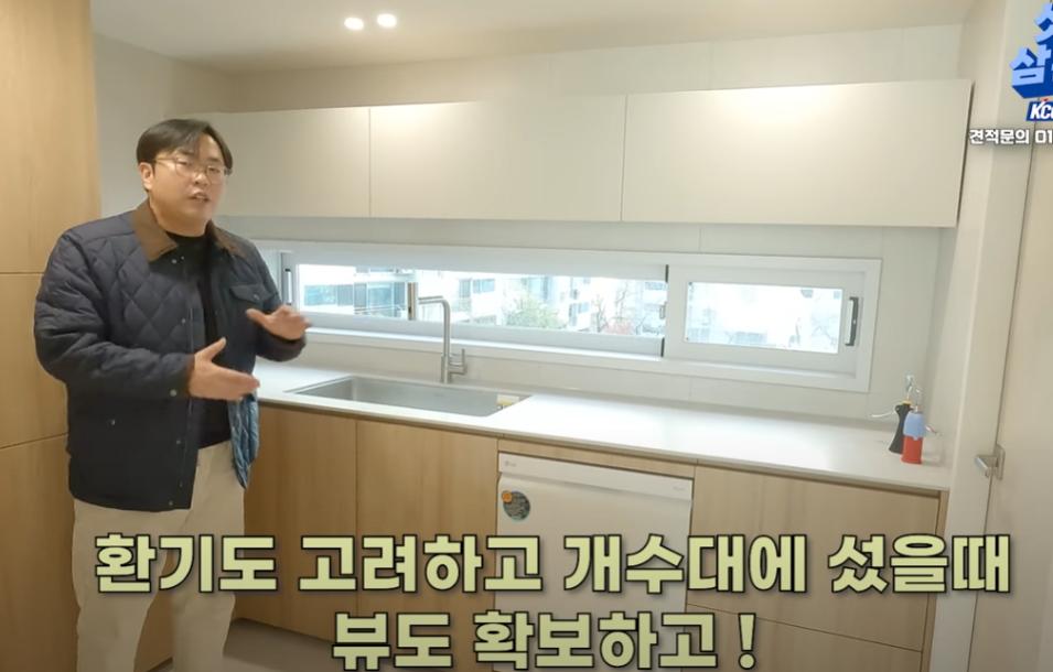 백색 상부장과 목재 하부장이 설치된 주방 내부