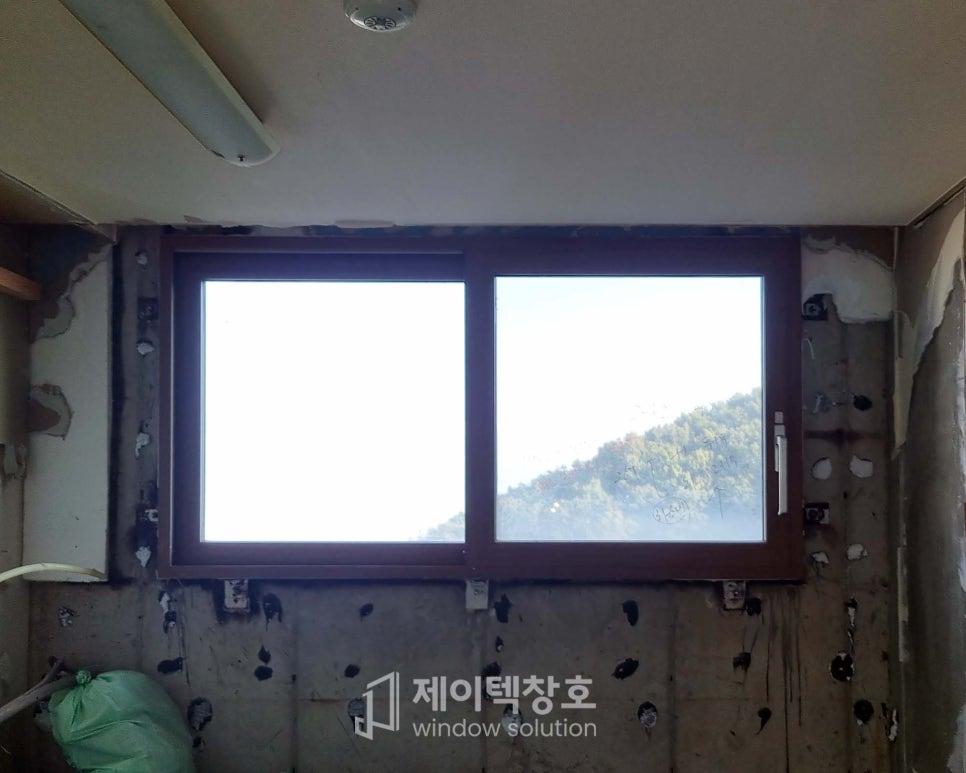 벽체가 부분적으로 벗겨진 상태에서 진행 중인 창호 고정 작업